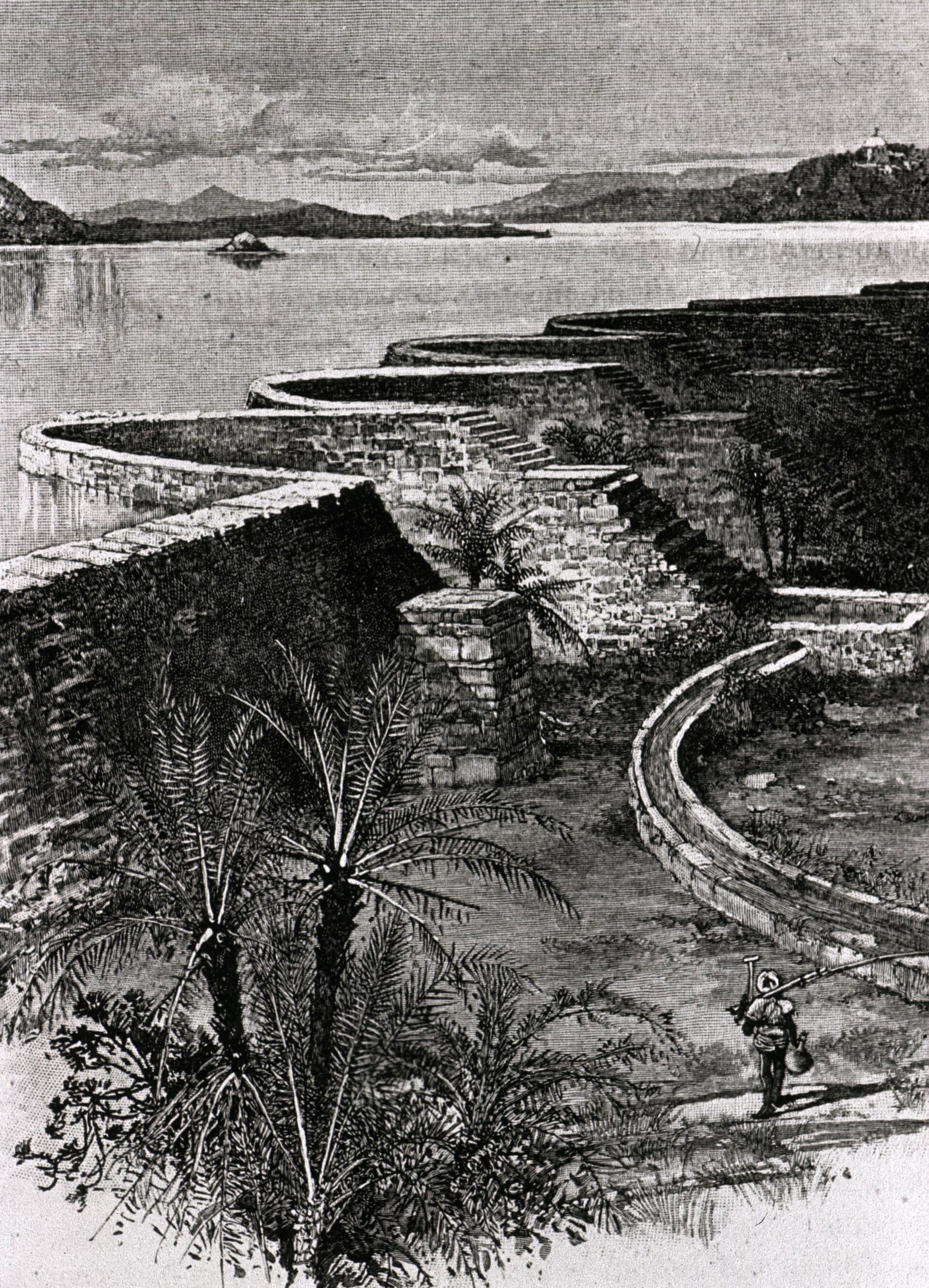 Nineteenth-century view of Mir Alam Tank near Hyderabad, showing the curved masonry dam running across the foreground in a series of linked semicircular arches, with the tank water and hills beyond.